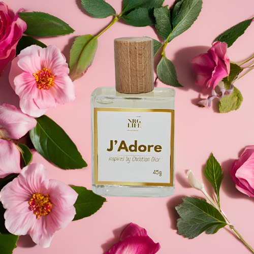 Adore Dupe perfume bottle surrounded by pink flowers and green leaves