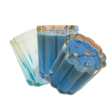 Two blue candles in decorative glass holders on a white background