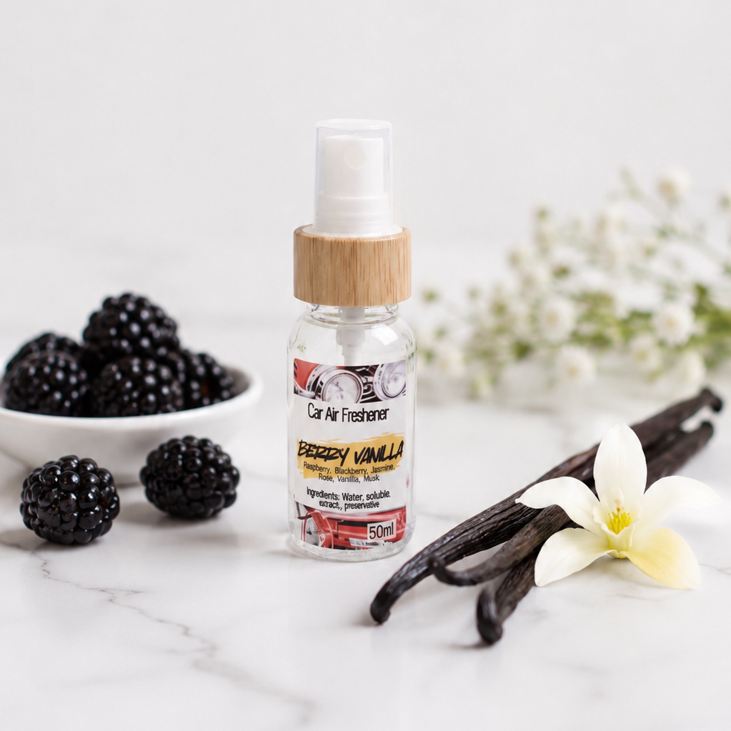 Berry Vanilla car air freshener bottle sitting on a marble table with flowers in the background.