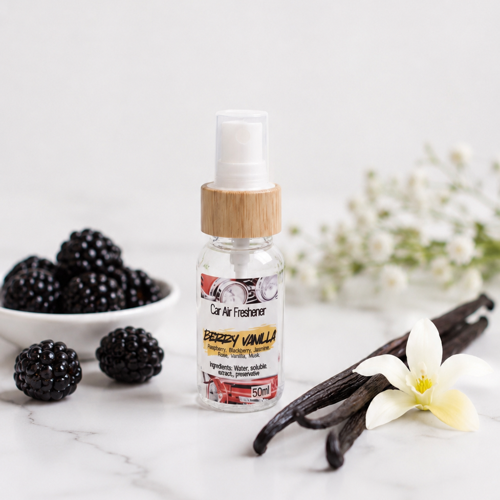 Berry Vanilla Car Air Freshener sitting on a marble table with a sprig of vanilla and some black berries to the side.