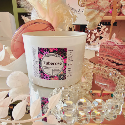 A large white candle infused with our floral fragrance Tuberose, featured with Rose Gold Lid to the back.