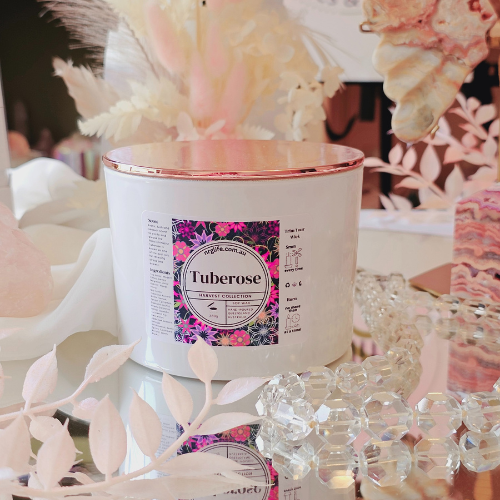 A large white candle infused with our floral fragrance Tuberose, featured with Rose Gold Lid on top.