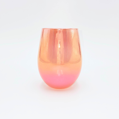 A candle making glass jar in the colour of blood orange of cerise. It is Iridescent or ironplate in design.