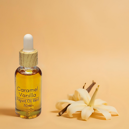 Diffuser bottle of Caramel Vanilla fragrant oil blend with vanilla flowers on a beige background.