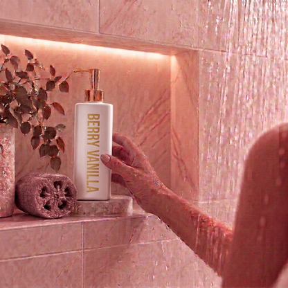 500ml Triangle White Berry Vanilla Coconut Body Wash sitting in a shower niche with softened dusty berry loofah and accents.