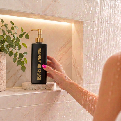 500ml Triangle Black bottle of Coconut Body Wash with a  Watermelon Splash fragrance sitting in a shower niche.