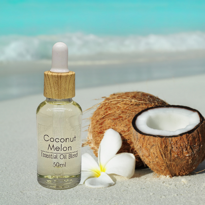 30ml Diffuser Coconut Melon 'Essential Oil' blend bottle beside coconuts and a flower on a beach.