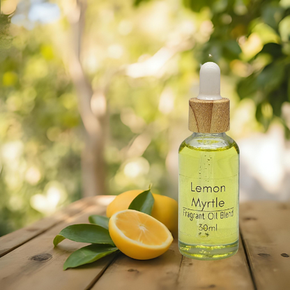 Diffuser bottle of Lemon Myrtle essential oil blend with lemons and leaves on the side sitting on a wooden surface.