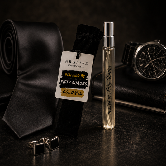 A clear cylindrical cologne Inspired by Fifty Shades 10ml spray bottle with a silver cap stands beside a rolled black necktie with a branded hangtag, with cufflinks and a wristwatch in a dark styled setting. This is our inspired version of this fragrance and not an original.