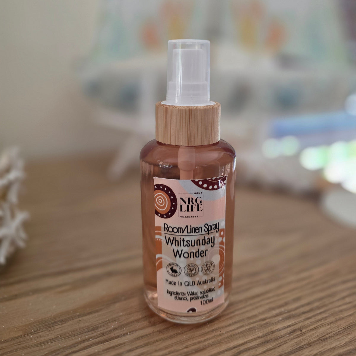 100ml Bottle of 'Whitsunday Wonder' Room Linen Spray with wooden cap on a wooden surface.