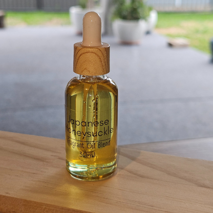 30ml Diffuser Bottle of Japanese honeysuckle fragrant oil blend with wooden dropper on a light timber surface.