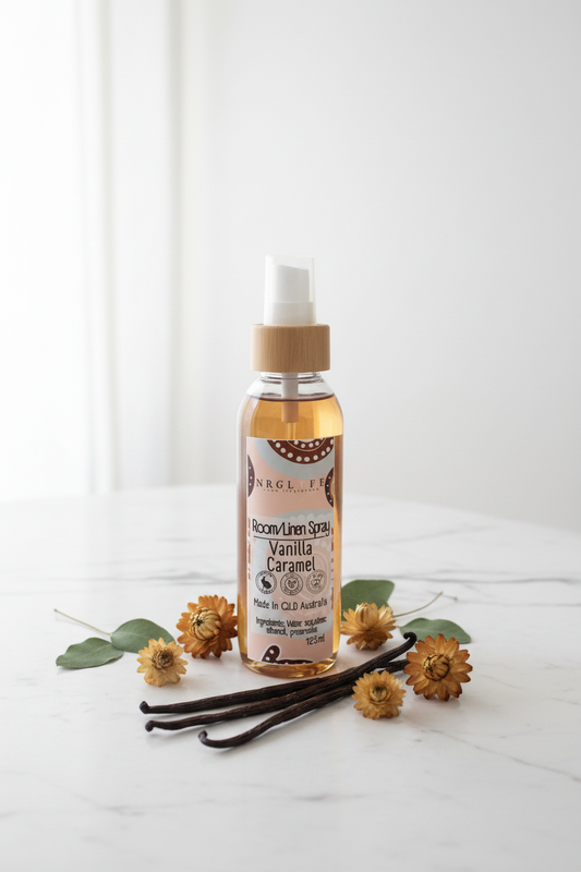 Vanilla caramel spray bottle with vanilla beans and flowers on a white background