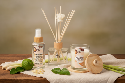 Aromatherapy diffuser, candle, and room linen spray in the fresh scent of Lemongrass & Kaffir Lime on a wooden surface with a neutral background