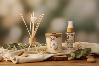Aromatherapy Diffuser, Eco-Candle, and Room Linen Spray in the scent called Linen on a wooden surface with a blurred natural background.